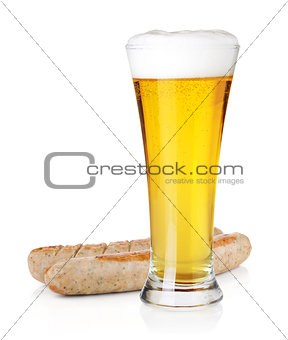 Light beer in glass and two grilled sausages