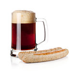 Dark beer in glass and two grilled sausages