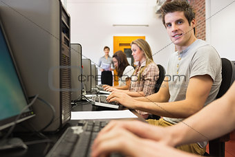 Students sitting at the computer room with man smiling
