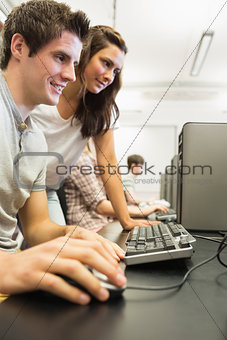 Students sitting at the computer while smiling