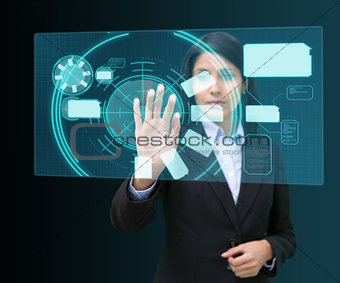 Businesswoman standing while touching at a hologram