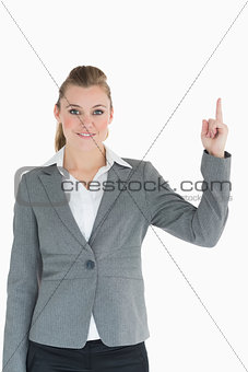 Smiling businesswoman pointing up in the air