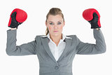 Businesswoman raising her hands with boxing gloves