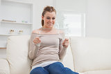 Woman holding a clear pane while smiling on the sofa