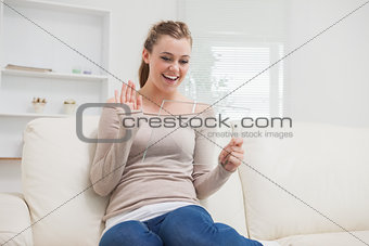 Woman waving at clear pane on the sofa