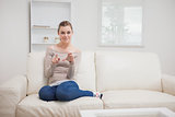 Woman holding a clear pane while sitting on the sofa