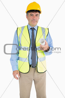 Architect in vest and helmet holding a plan