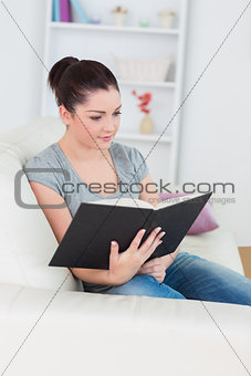 Woman sitting on the couch and reading a book