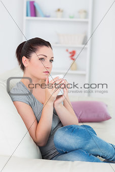 Thoughtful woman sitting on the couch