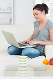 Smiling woman using a laptop on the couch