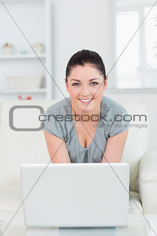 Woman sitting on the couch and using a laptop