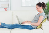 Woman sitting on the couch and working with a laptop