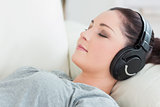 Relaxing woman lying on the couch and listening to music