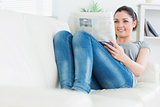 Relaxing woman lying on the couch and reading newspaper