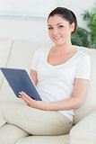 Woman sitting on the couch and using a tablet pc