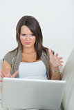 Woman looking wary of laptop