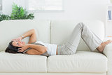Woman lying on the sofa and listening music