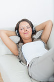 Smiling woman using headphone to listen music