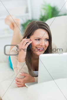 Smiling woman calling in front of her laptop