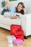 Woman looking at credit card and phoning
