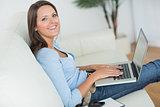 Woman sitting on sofa with her laptop