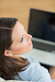 Woman looking away from laptop