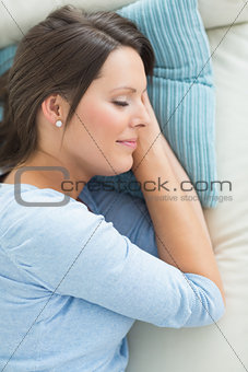Smiling woman lying and sleeping on sofa