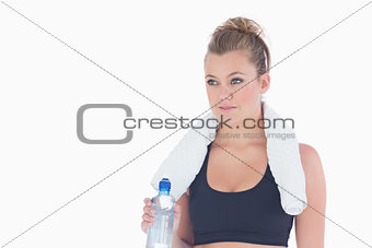 Woman standing holding a bottle of water and a towel