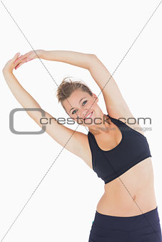 Woman leaning left while smiling and stretching