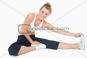 Woman sitting and stretching while smiling
