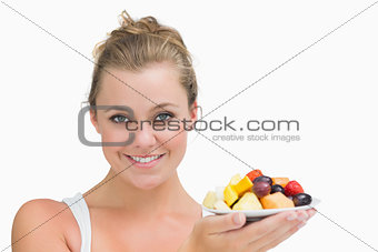Woman holding up a plate fruits