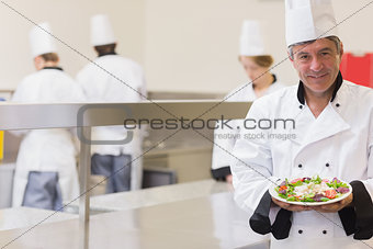 Smiling chef presenting his salad