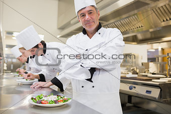 Chef smiling with others preparing salads