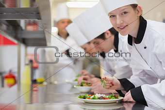 Happy chef looking up from preparing salad