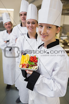 Smiling chef holding fruit plate