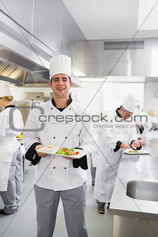 Happy chef holding a salmon dish