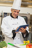 Chef using digital tablet and smiling