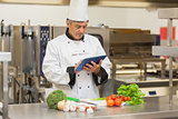 Chef preparing recipe with digital tablet