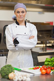 Chef standing beside chopping board and vegetables