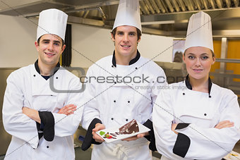 Three Chef\'s presenting a cake