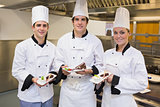 Three Chef's presenting cakes