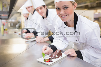 Smiling Chef's finishing dessert plates