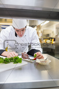 Chef putting mint leaf with cake