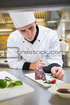 Chef putting mint with chocolate cake