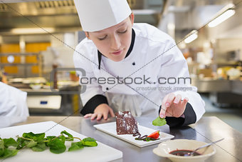 Chef putting mint with her chocolate cake