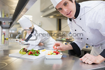 Happy chef preparing a fruit salad