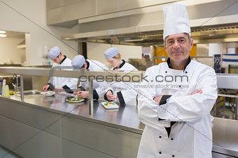 Head chef smiling in busy kitchen