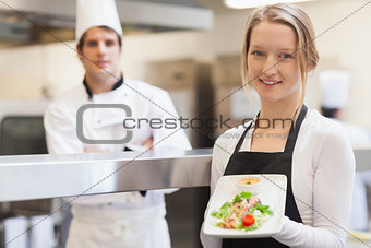 Smiling waitress carrying salmon plate