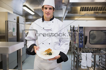Cheerful chef presenting his plate