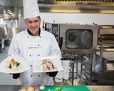 Chef holding two plates in the kitchen